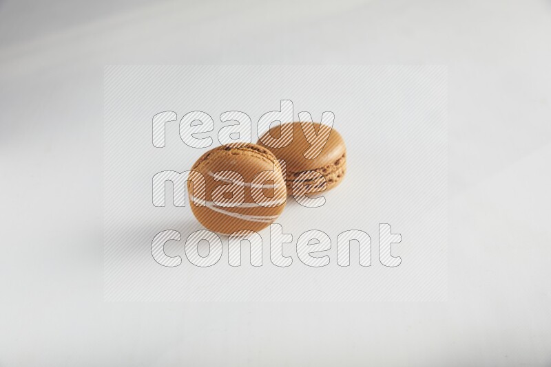 45º Shot of of two assorted Brown Irish Cream, and Brown Maple Taffy macarons  on white background