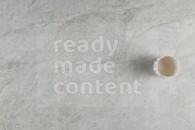 A multicolored pottery Cup on grey marble background