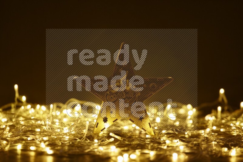 A traditional ramadan lantern surrounded by glowing fairy lights in a dark setup