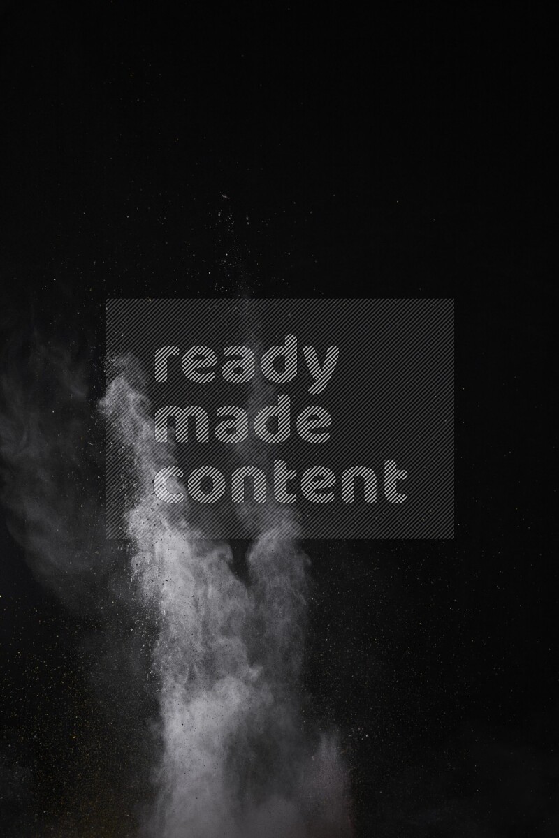 A side view of multicolored powder explosion on black background
