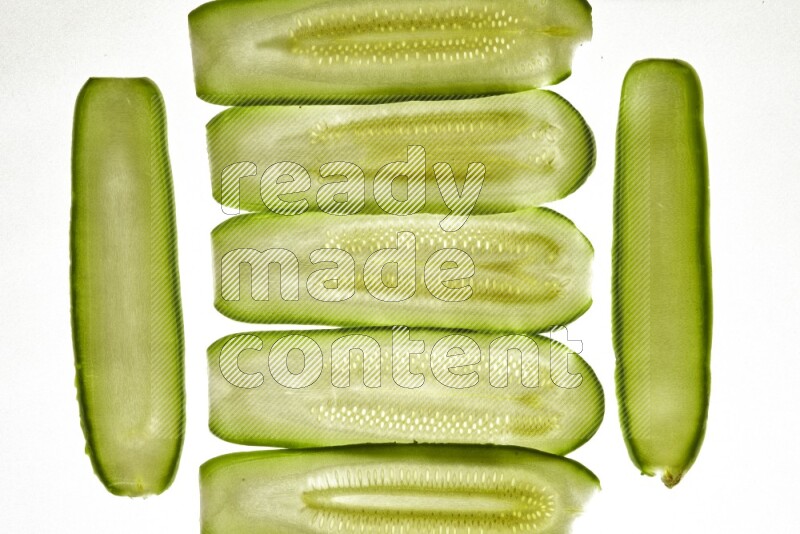 Zucchini slices on illuminated white background