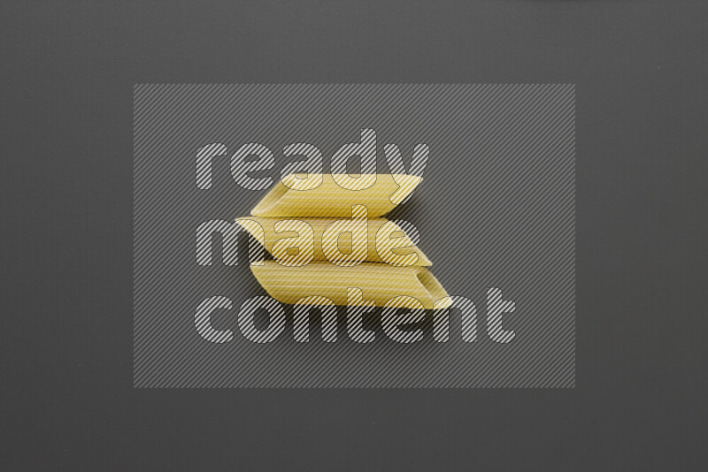 Penne pasta on grey background
