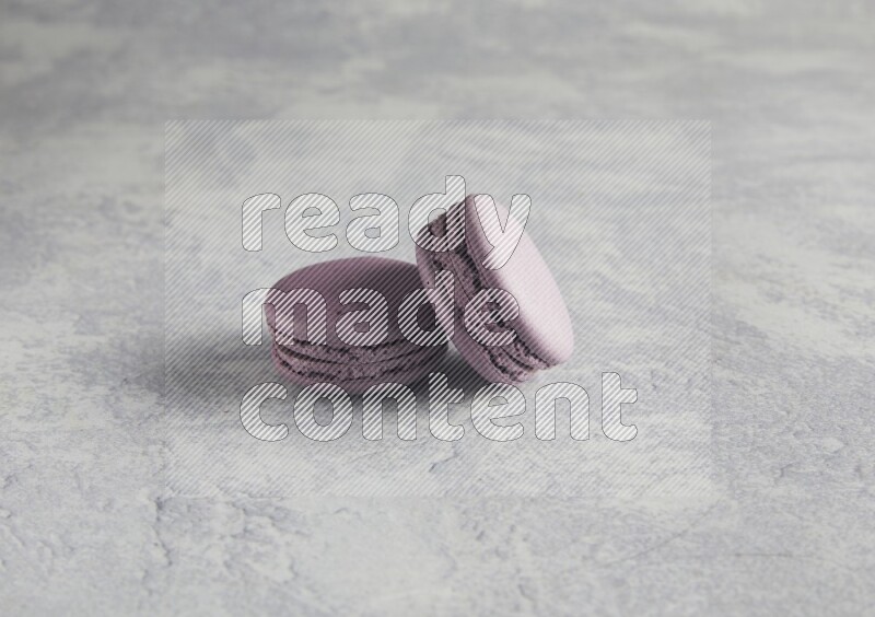 45º Shot of two Purple Blueberry macarons  on white  marble background