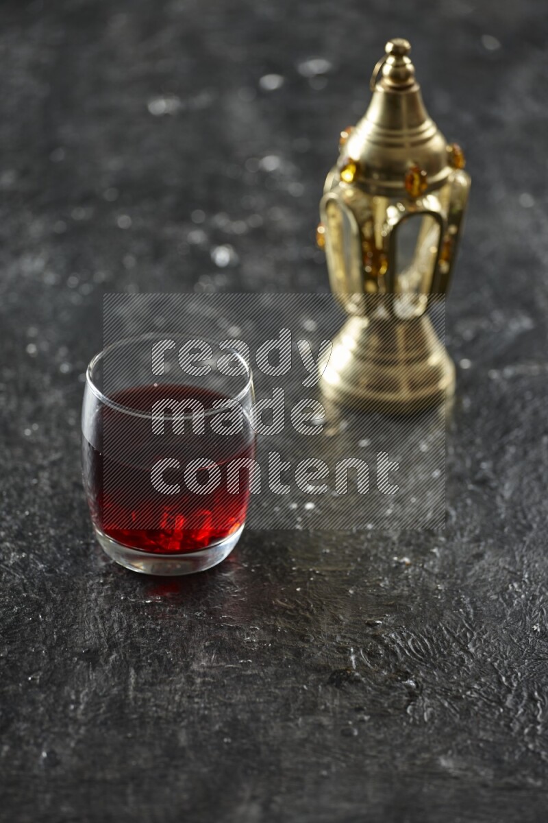 فانوس ذهبي مع مشروبات مختلفة وتمر ومكسرات وسبحة صلاة وقرآن على خلفية سوداء