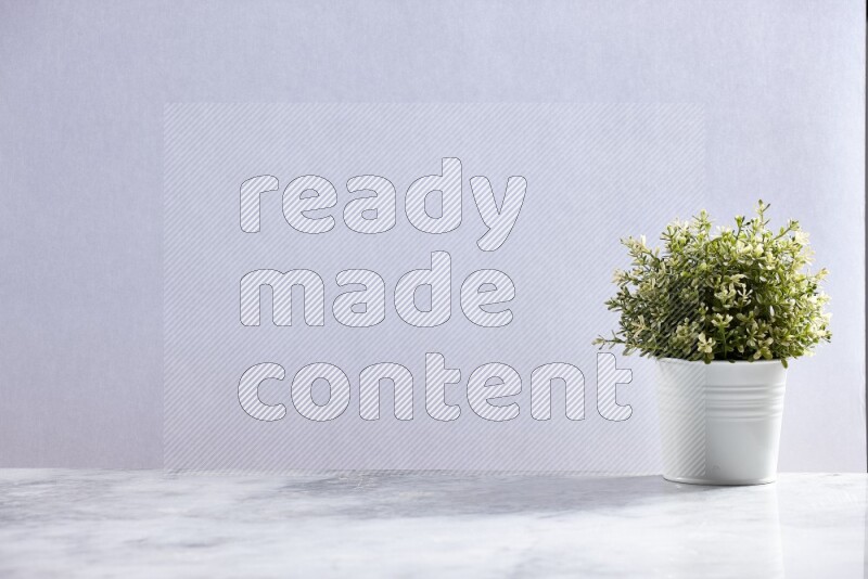 Artificial plant in white pot on grey marble background