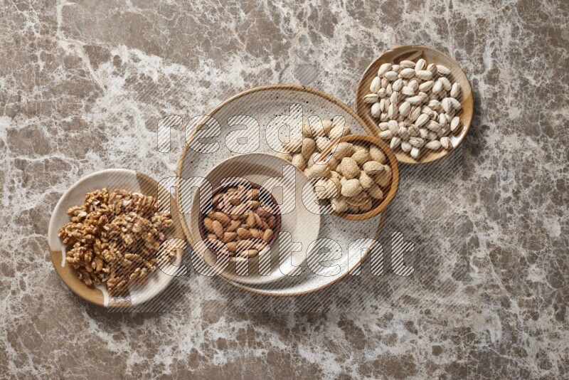 مكسرات في أطباق فخارية وخشبية