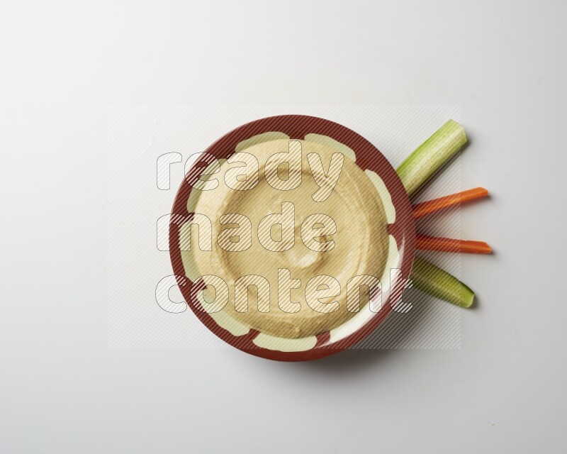Plain hummus in a traditional plate on a white background