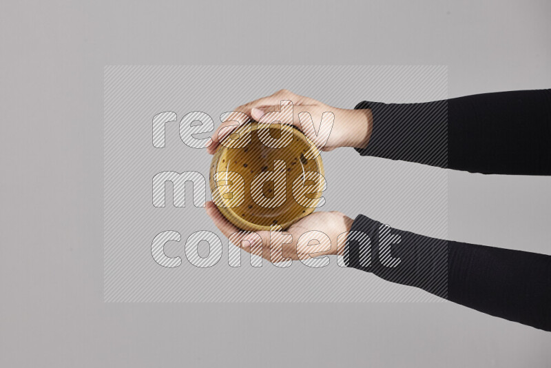 A woman in black abaya holding different pottery essentials in different positions