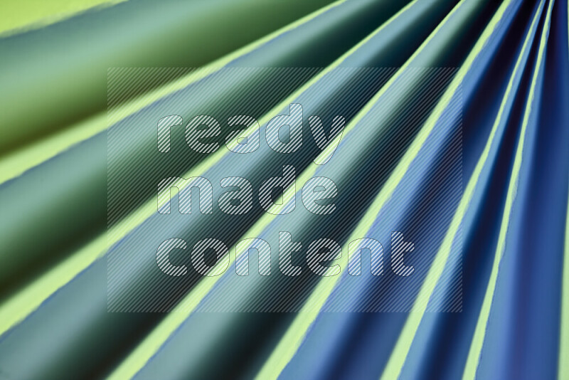 An image presenting an abstract paper pattern of lines in green and blue tones