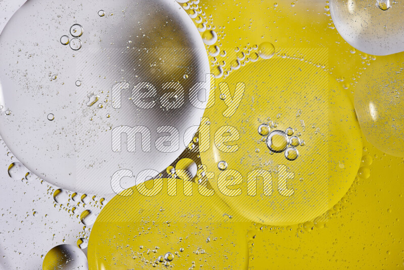 Close-ups of abstract oil bubbles on water surface in shades of white and yellow