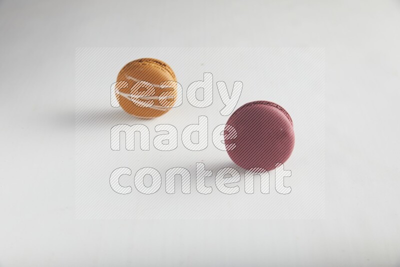 45º Shot of of two assorted Brown Irish Cream, and Red Cherry macarons on white background