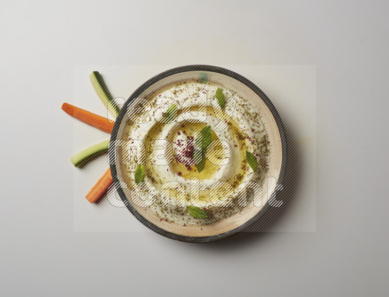 Lebnah garnished with zaater, mint & sumak in a pottery plate on a white background