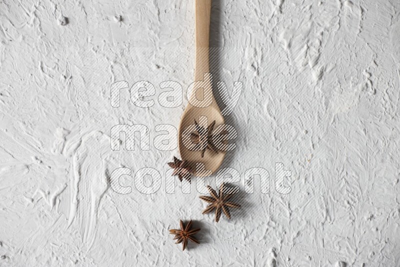 Star Anise in a wooden spoon on white flooring