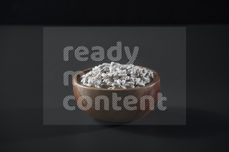Snacks in a wooden bowl on grey background