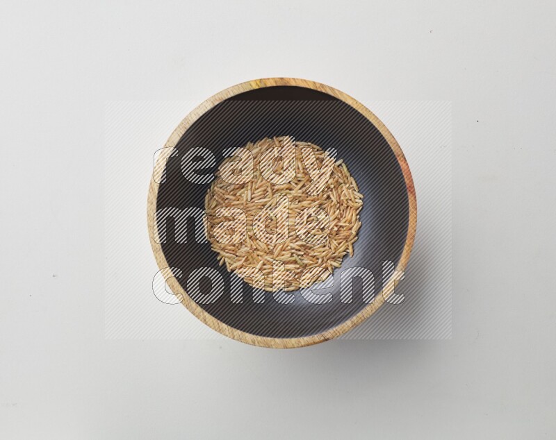 Top-view shot of long grain brown rice in a container on white background