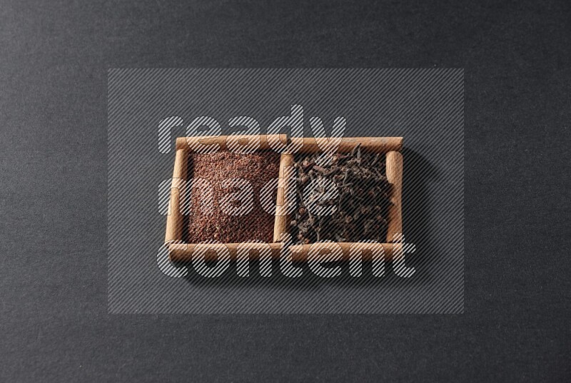 2 squares of cinnamon sticks full of garden cress and cloves on black flooring