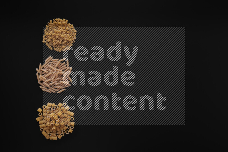 Different pasta types in 3 bunches on black background