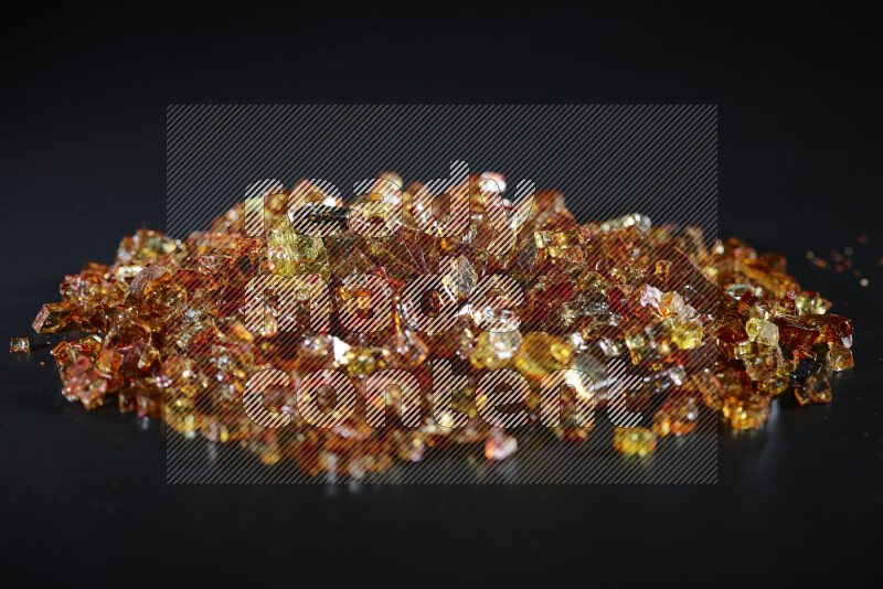 قطع زجاج برتقالية شفافة متناثرة على خلفية سوداء