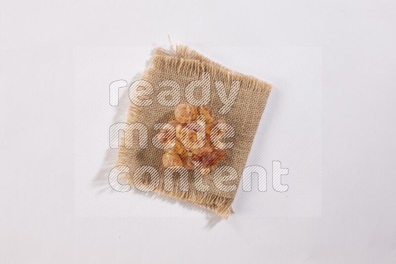 Gum arabic on a burlap piece on white flooring