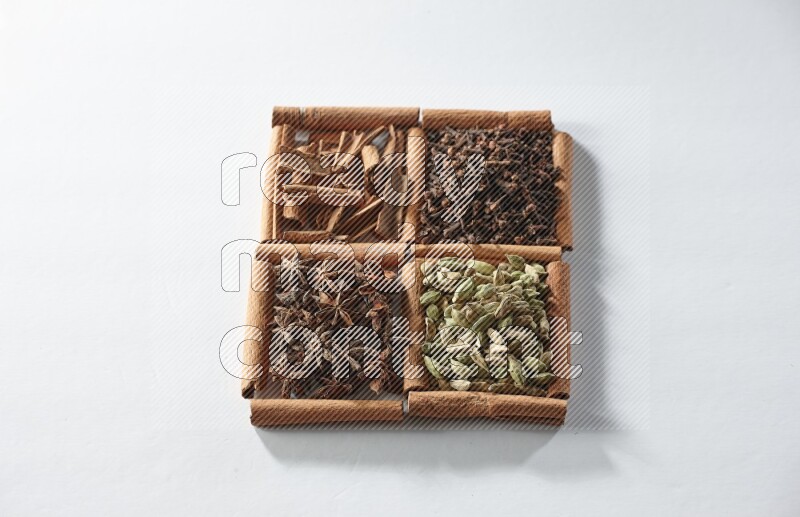 4 squares of cinnamon sticks full of cardamom, star anise, cloves and cinnamon on white flooring