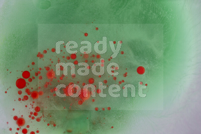 تلتقط الصورة تناثرا للطلاء الأحمر علي خلفية خضراء