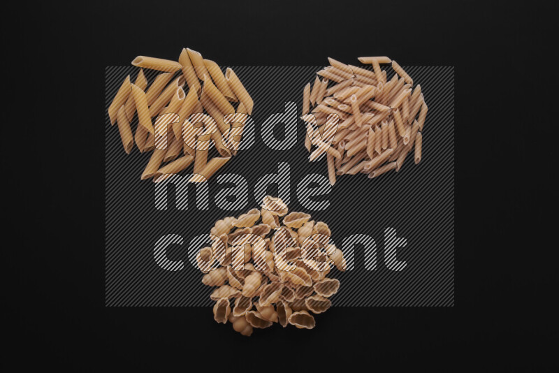 Different pasta types in bunches on black background