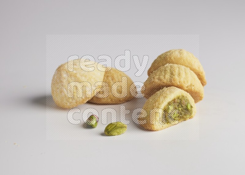 Five Pieces of Maamoul filled with pistachio  paste one of them is cut direct on white background