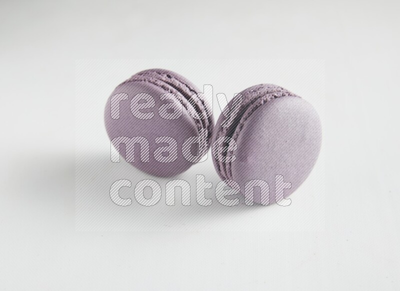 45º Shot of two Purple Blueberry macarons on white background