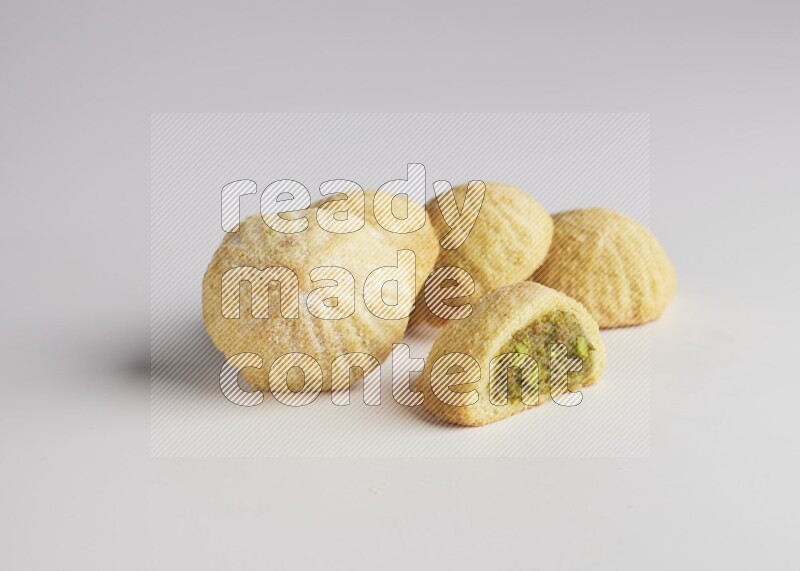 Five Pieces of Maamoul filled with pistachio  paste one of them is cut direct on white background