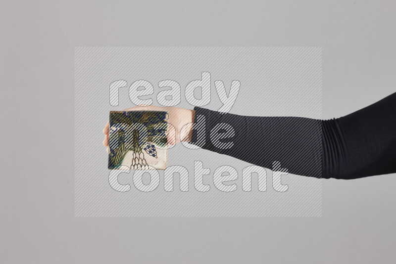 A woman in black abaya holding different pottery essentials in different positions