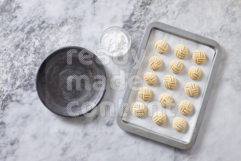 Kahk step by step with its ingredients ghee, sugar, flour, sesame, yeast, water and kahk flavor on grey marble background