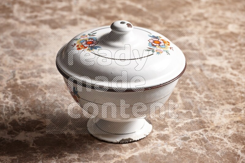 A vintage metal bowl on beige marble background