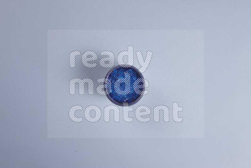 أوعية فخارية متعددة الألوان مليئة بالأزرار الملونة على خلفية زرقاء