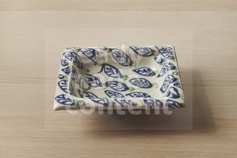 A decorative pottery plate on light wooden background