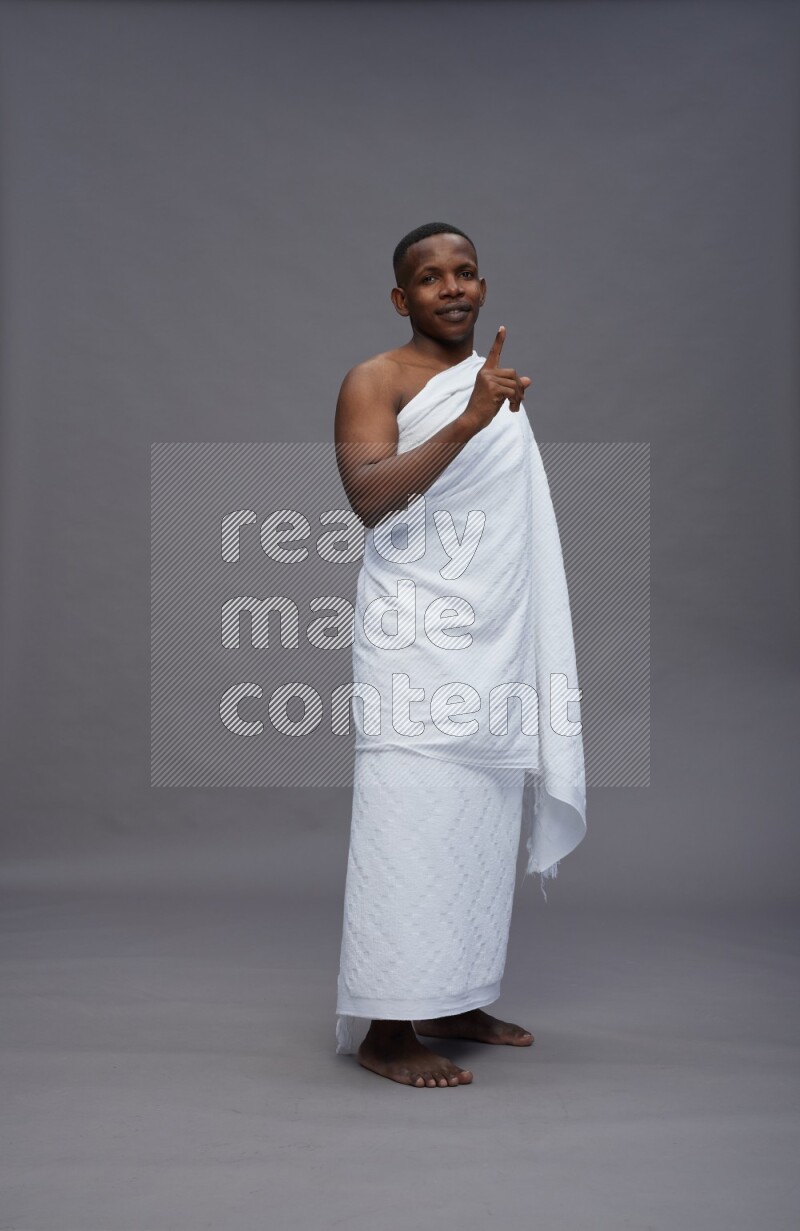 A man wearing Ehram Standing Interacting with the camera on gray background