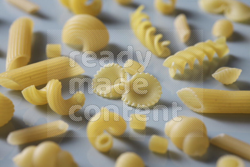 Different pasta types on light blue background