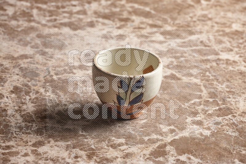 A decorative pottery bowl on beige marble background