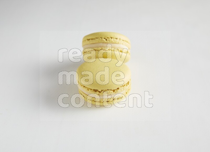 45º Shot of two Yellow Lime macarons on white background