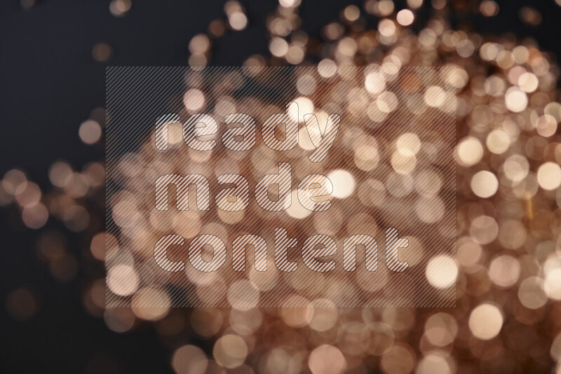 قطع زجاجية برونزية لامعة متناثرة على خلفية سوداء