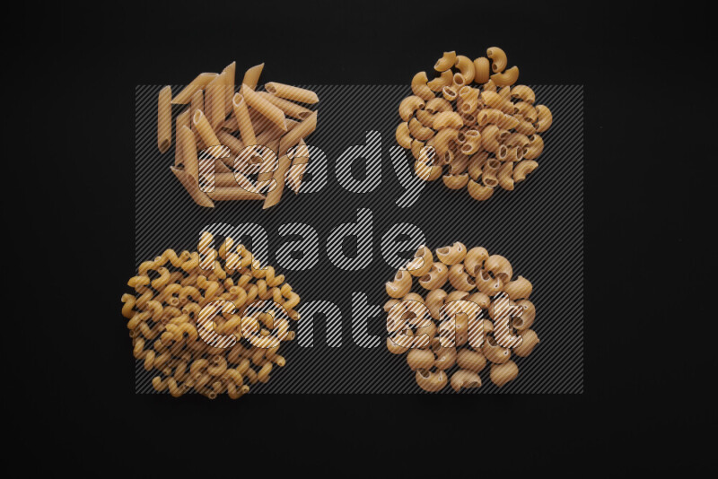 Different pasta types in bunches on black background