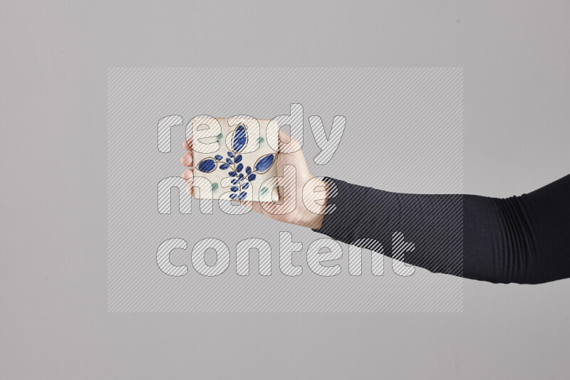 A woman in black abaya holding different pottery essentials in different positions
