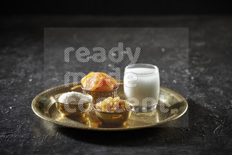 Dried fruits in metal bowls with sobya on a tray in dark setup