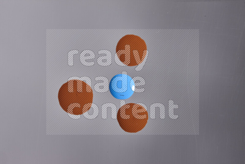 Close-ups of abstract orange and blue paint droplets on the surface