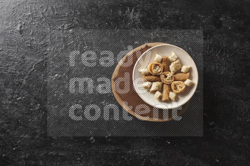 حلويات شرقية في أطباق فخارية علي خلفية سوداء خشبية