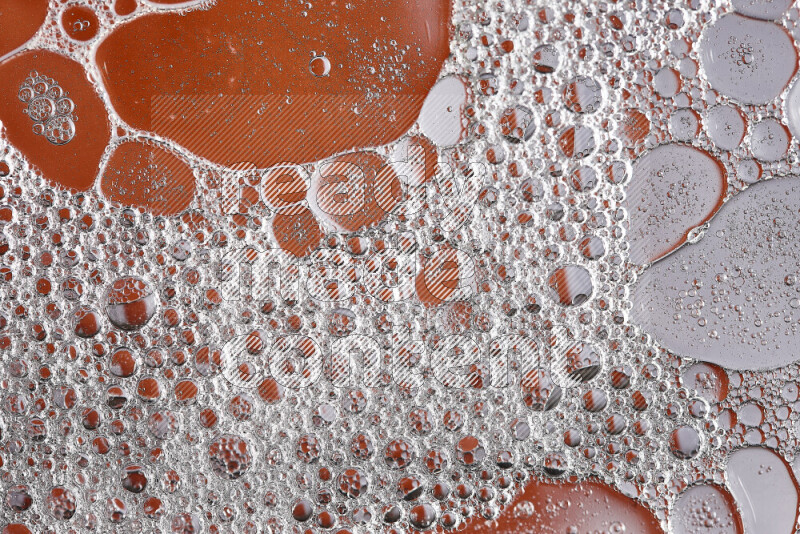 Close-ups of abstract soap bubbles and water droplets on orange background