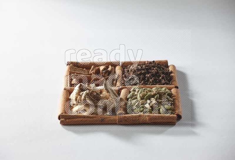 4 squares of cinnamon sticks full of cardamom, cinnamon, cloves and dried ginger on white flooring