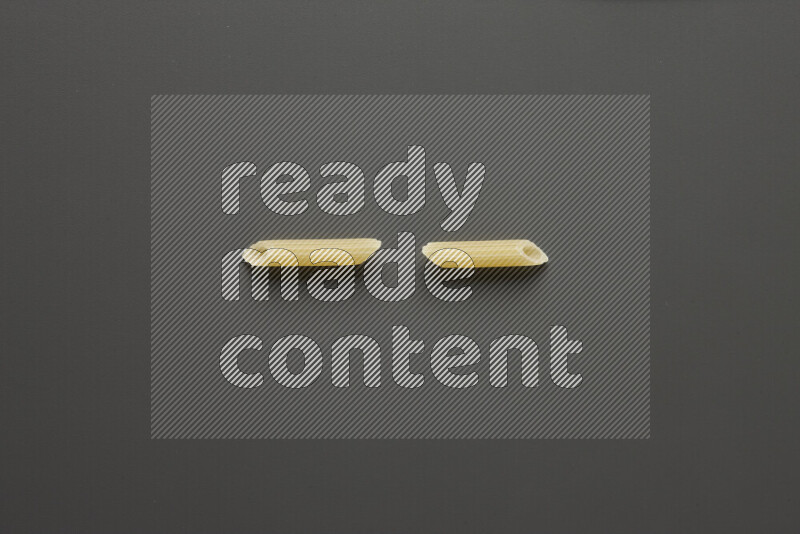 Mini penne pasta on grey background