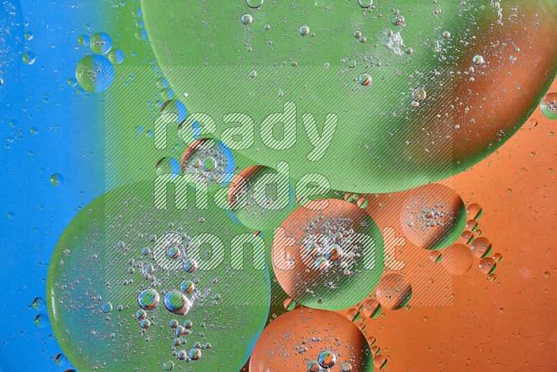 Close-ups of abstract oil bubbles on water surface in shades of orange, green and blue