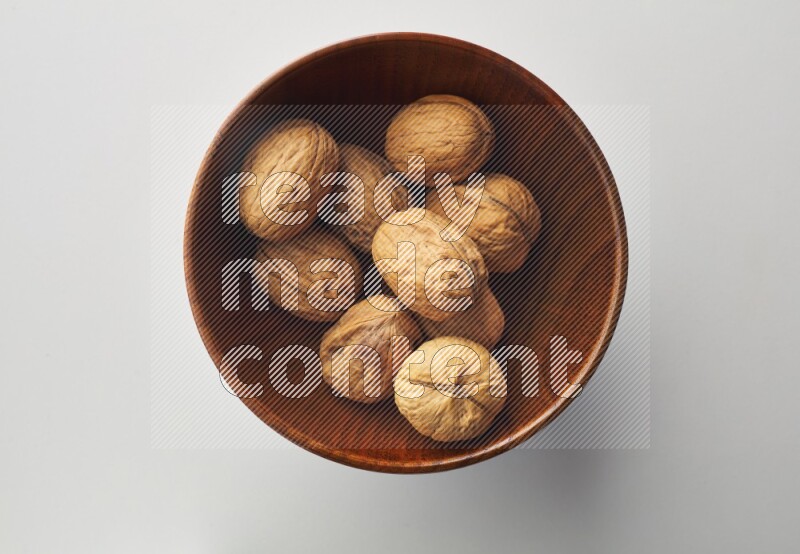 Top-view shot of walnut in a container on white background