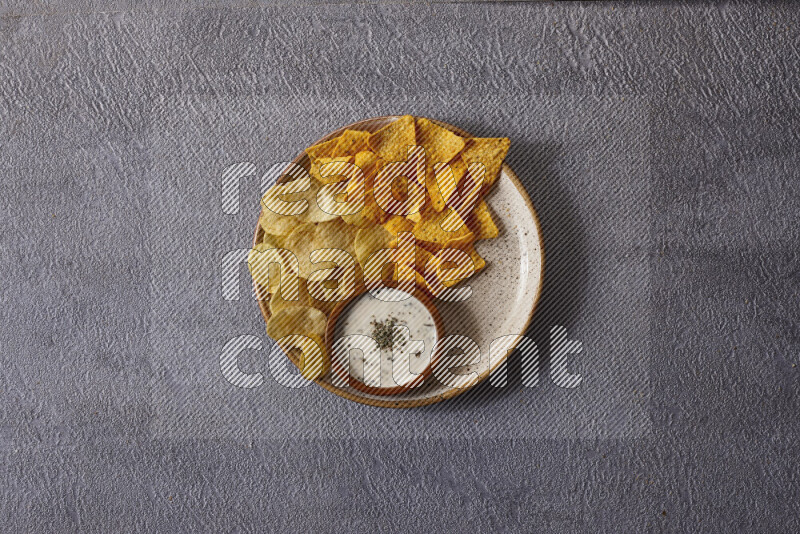 Assorted snacks in pottery bowls on grey background